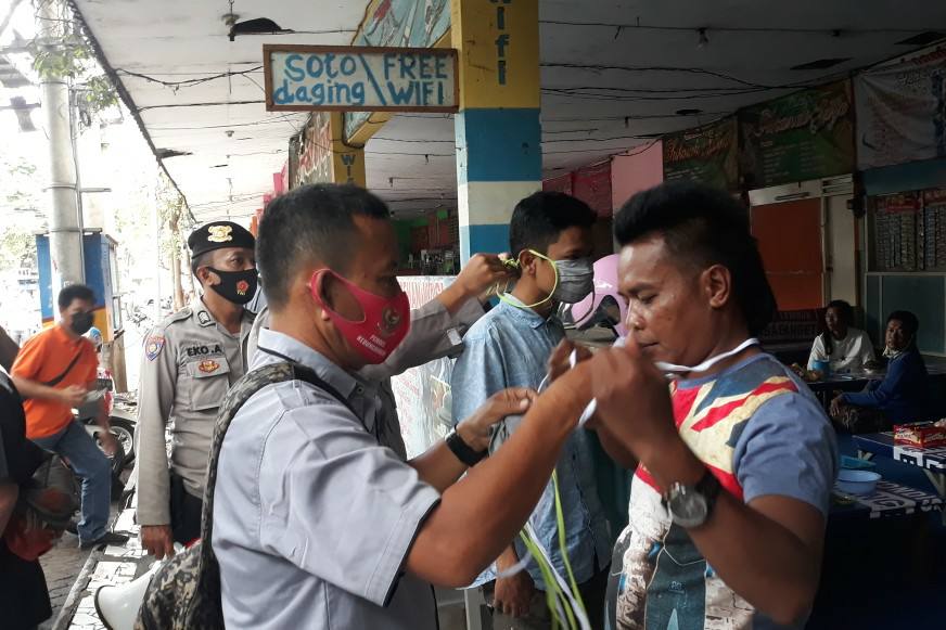 Dikawal Polisi, PWI Pasuruan Bagikan 1000 Masker Kepada Pedagang Pasar Kebonagung Dalam Rangka HPN Ke 75